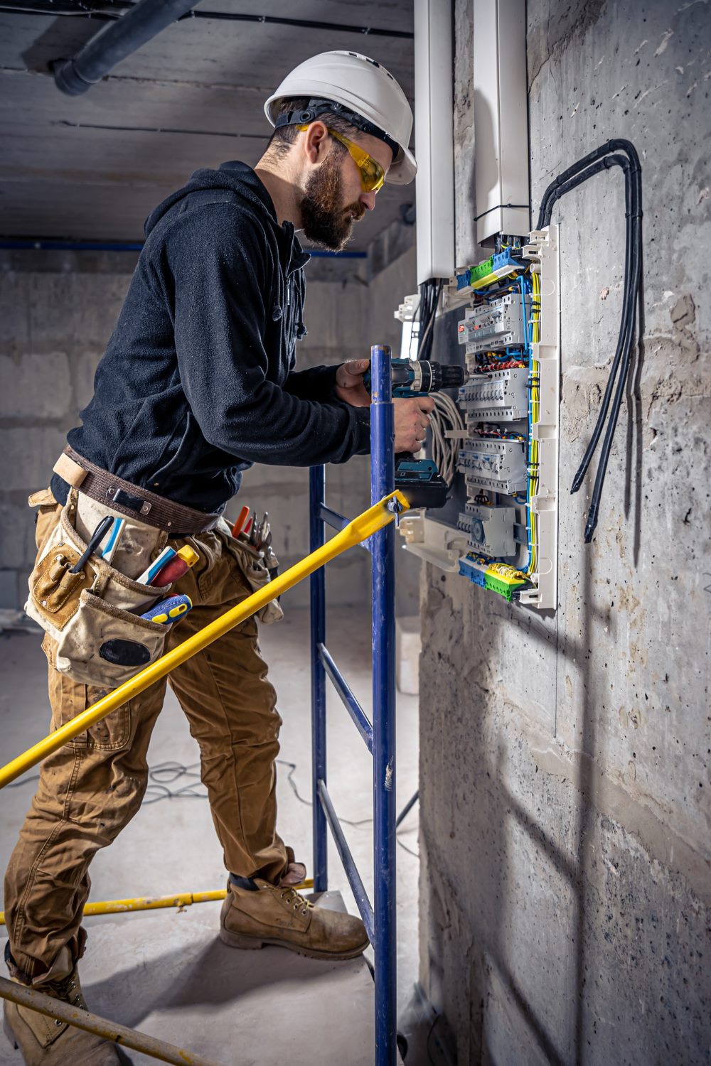 Eletricista fazendo manutenção em quadro elétrico