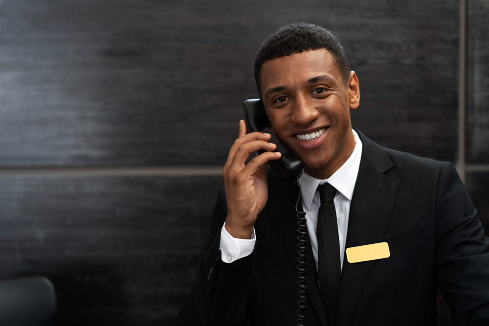 Porteiro uniformizado atendendo ao telefone
