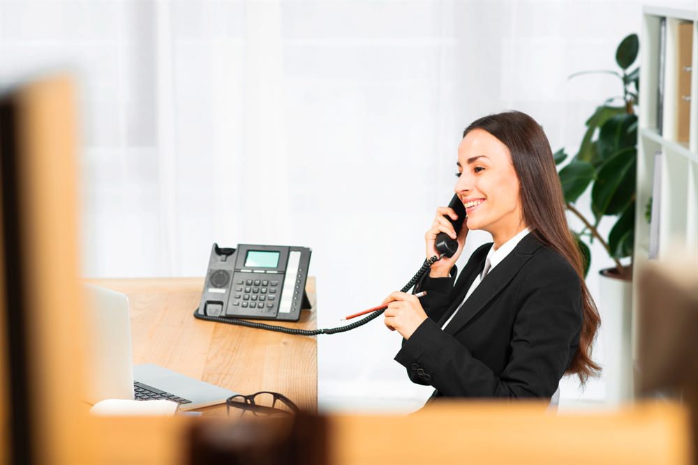 Recepcionista atendendo ao telefone em escritório